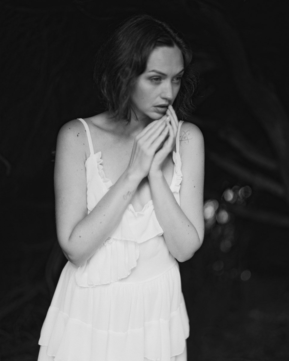 Analogue portrait in black and white of a woman with a white dress