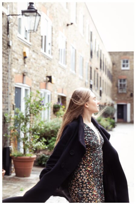 Fine art photograph of a woman dancing freely in a London mews, capturing an ethereal, joyful moment in the city.